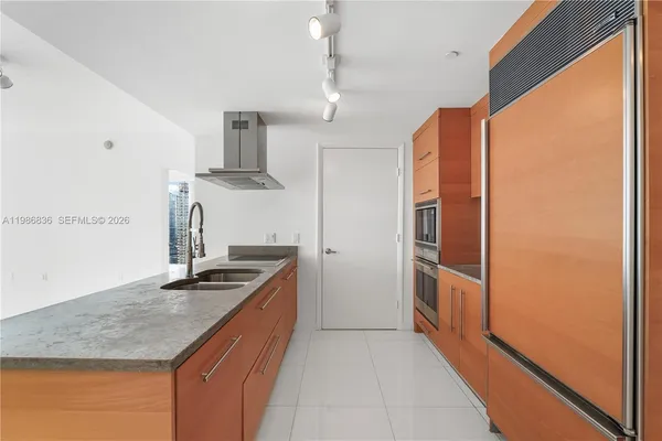 a kitchen with stainless steel appliances granite countertop a sink and a refrigerator