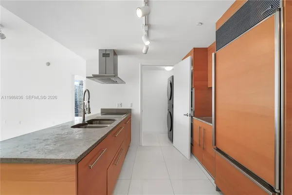 a kitchen with stainless steel appliances granite countertop a sink and a refrigerator
