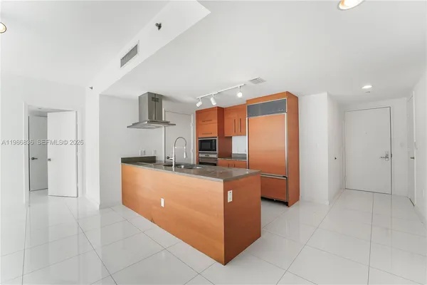 a kitchen with stainless steel appliances granite countertop a refrigerator and a stove top oven