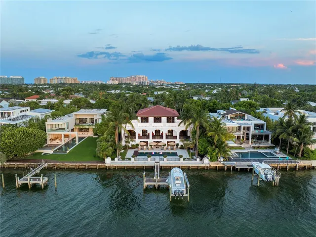 an aerial view of residential houses with outdoor space and ocean view