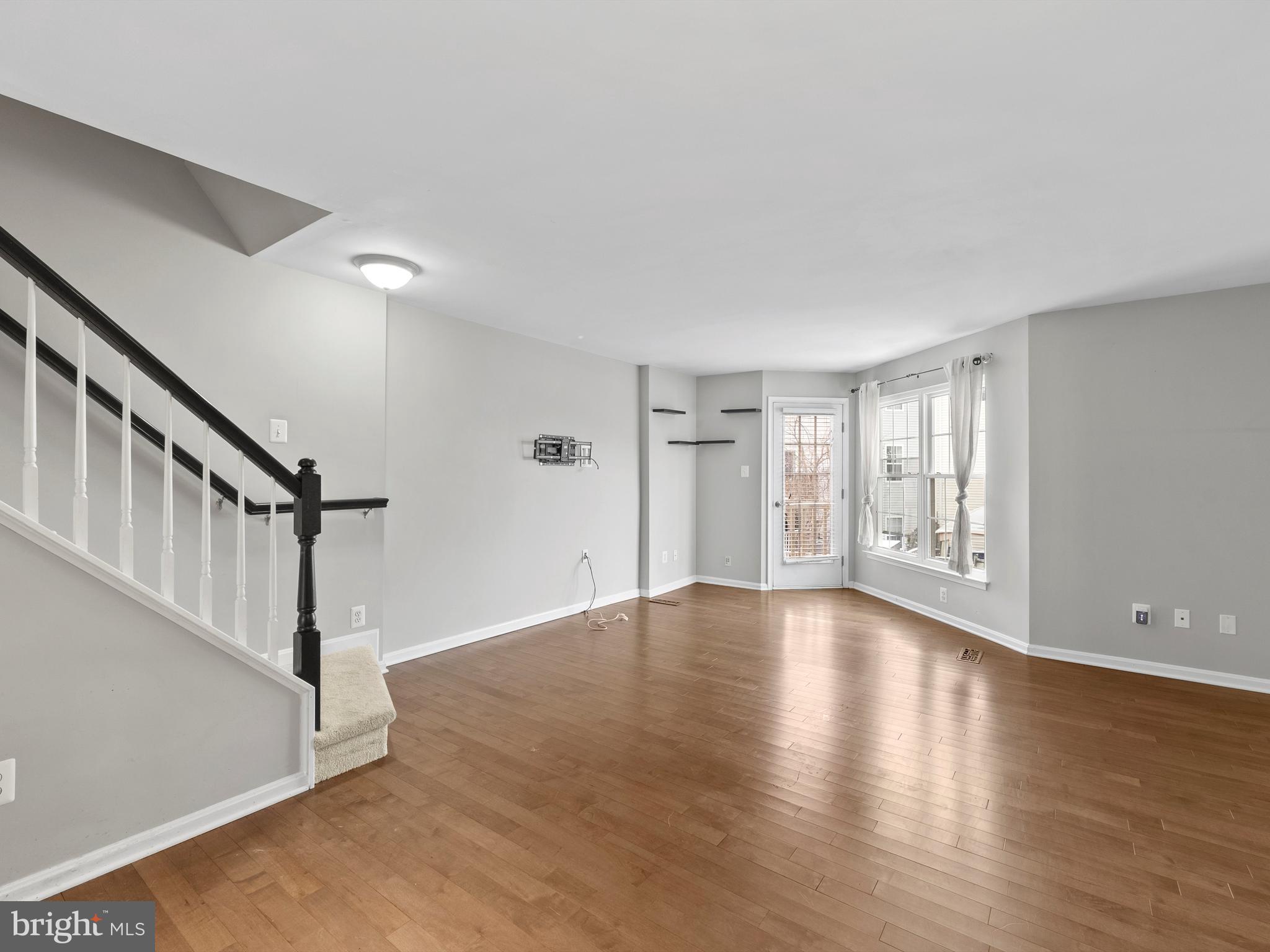 45458 Bluemont Junction Square Sterling, VA 20164 - Photo 7 of 24 a view of an empty room with wooden floor and a window
