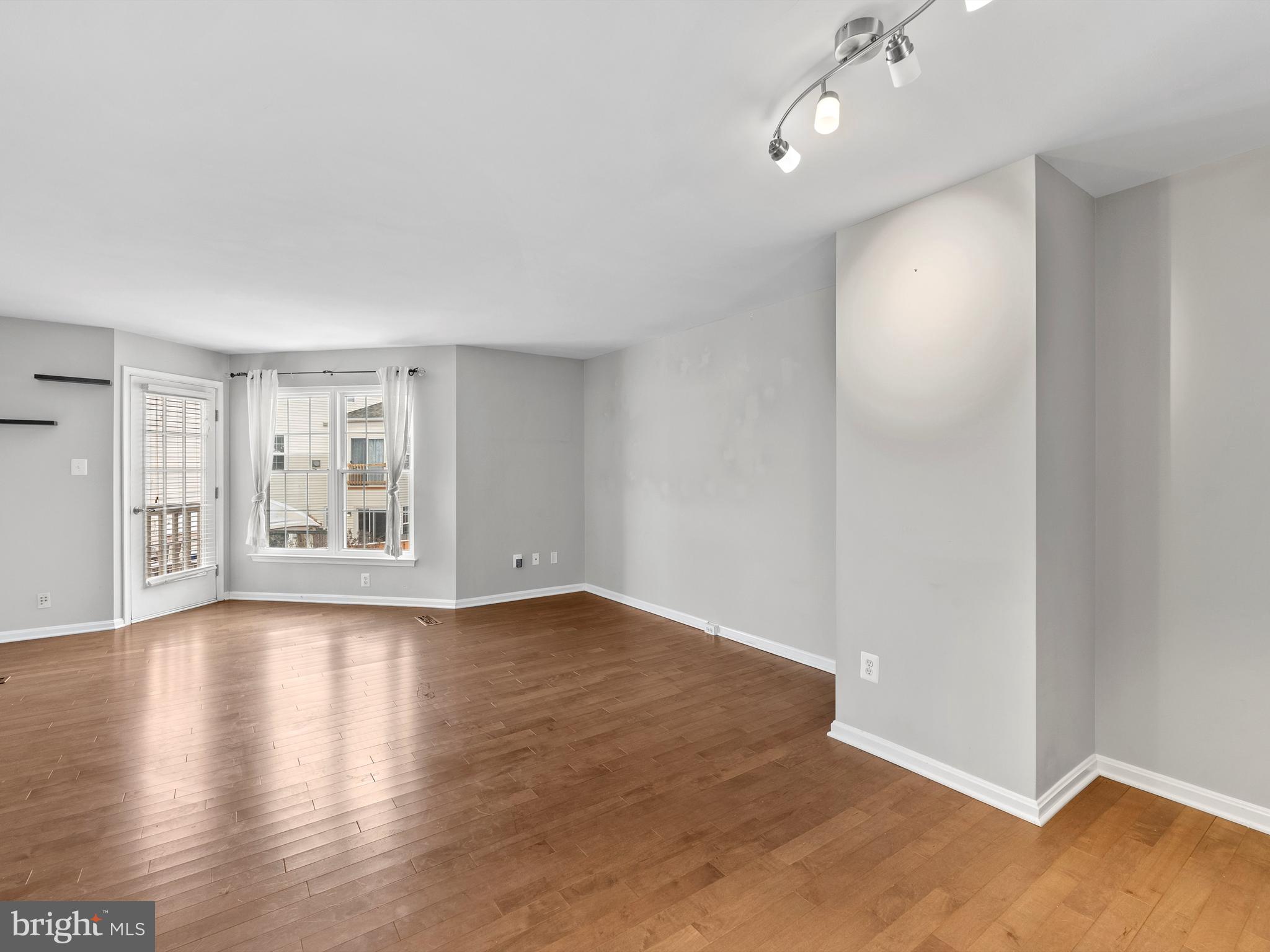 45458 Bluemont Junction Square Sterling, VA 20164 - Photo 9 of 24 a view of an empty room with wooden floor and a window
