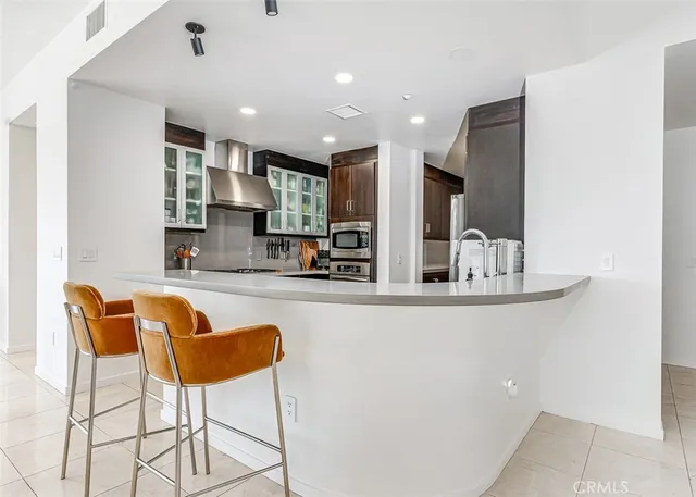 a kitchen with stainless steel appliances granite countertop a sink and a refrigerator