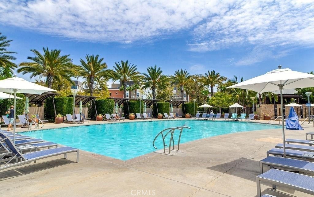 21 Gramercy, Unit 306 Irvine, CA 92612 - Photo 35 of 46 a view of a swimming pool with a table and chairs under an umbrella