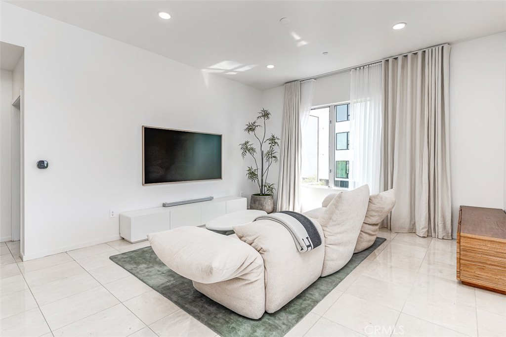 21 Gramercy, Unit 306 Irvine, CA 92612 - Photo 9 of 46 a living room with a couch and a flat screen tv