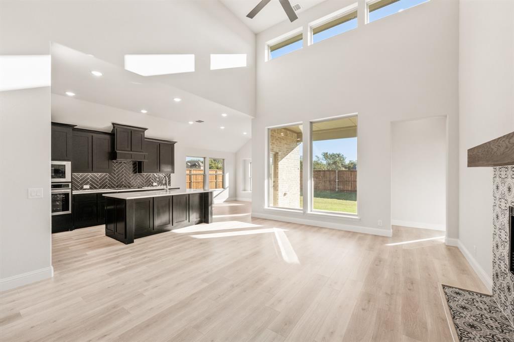 38 Osprey Street Joshua, TX 76058 - Photo 13 of 37 a kitchen with stainless steel appliances kitchen island wooden cabinets and granite counter tops