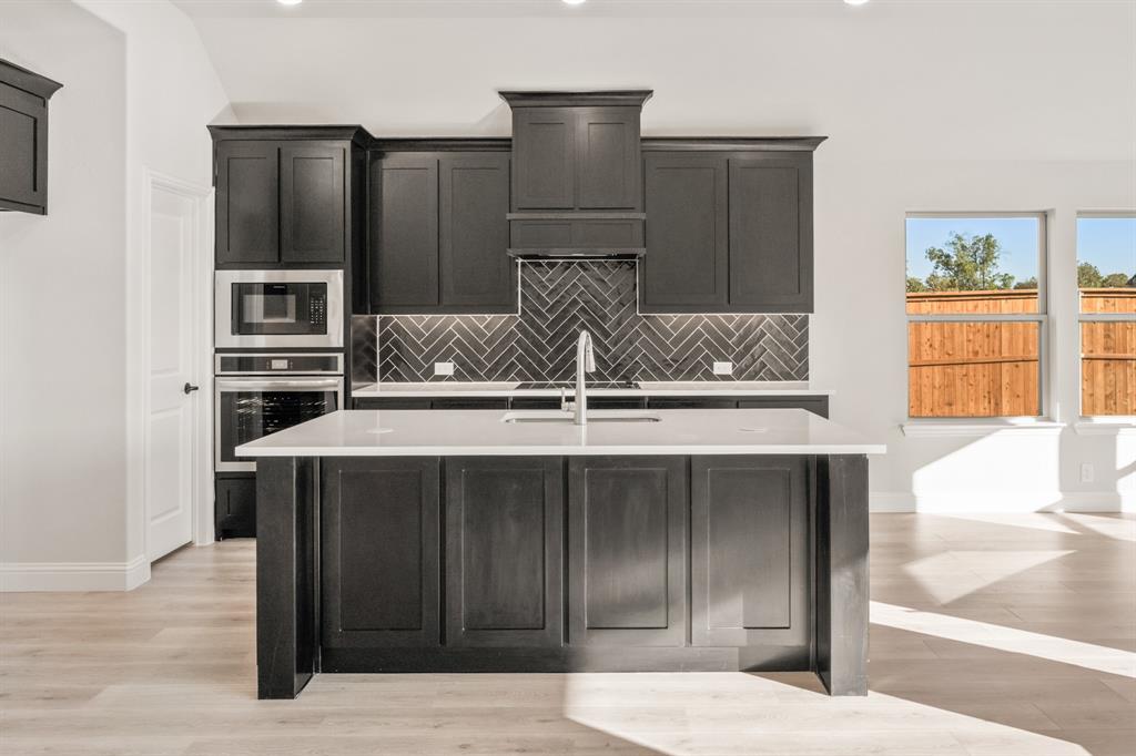 38 Osprey Street Joshua, TX 76058 - Photo 14 of 37 a kitchen with a sink and a refrigerator