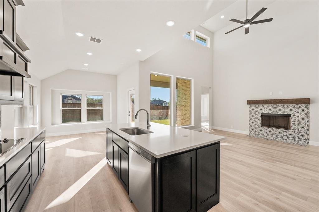38 Osprey Street Joshua, TX 76058 - Photo 20 of 37 a open kitchen with a sink and a stove top oven with granite countertops