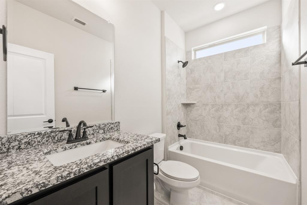 38 Osprey Street Joshua, TX 76058 - Photo 7 of 37 a bathroom with a granite countertop sink a toilet a mirror a bathtub and shower