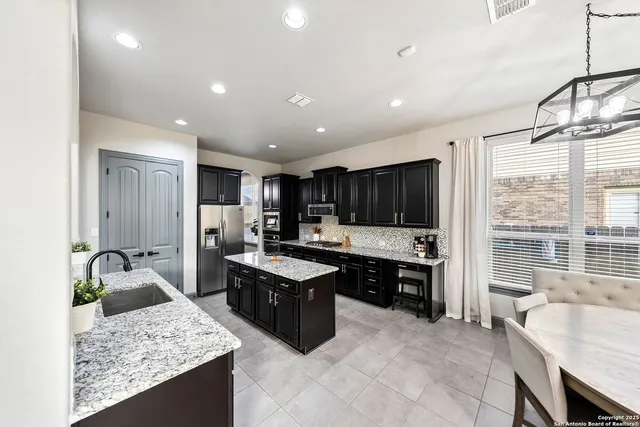 a dining room with furniture a chandelier and wooden floor