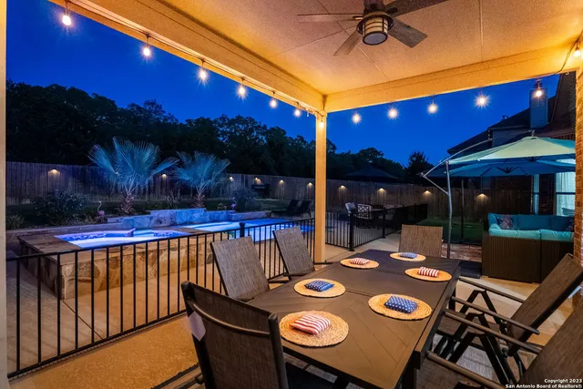 a view of a patio with a table and chairs under an umbrella with a fire pit