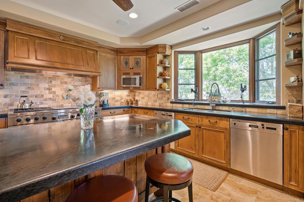 7187 Via De Maya Rancho Santa Fe, CA 92067 - Photo 2 of 10 a kitchen with a sink and wooden cabinets