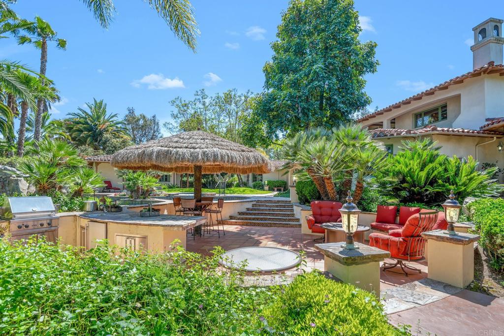 7187 Via De Maya Rancho Santa Fe, CA 92067 - Photo 8 of 10 a backyard of a house with a garden and outdoor seating