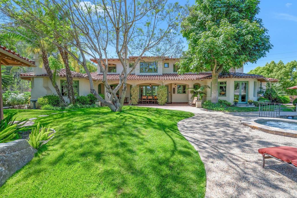 7187 Via De Maya Rancho Santa Fe, CA 92067 - Photo 9 of 10 a front view of a house with a yard table and large trees