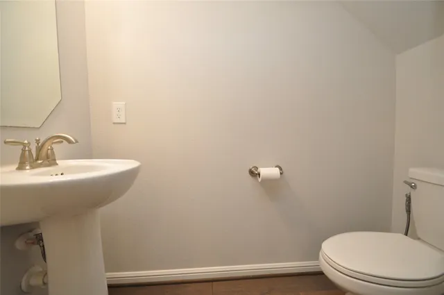 a bathroom with a sink mirror and toilet