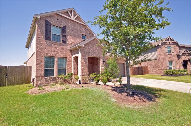 a front view of a house with a yard and trees