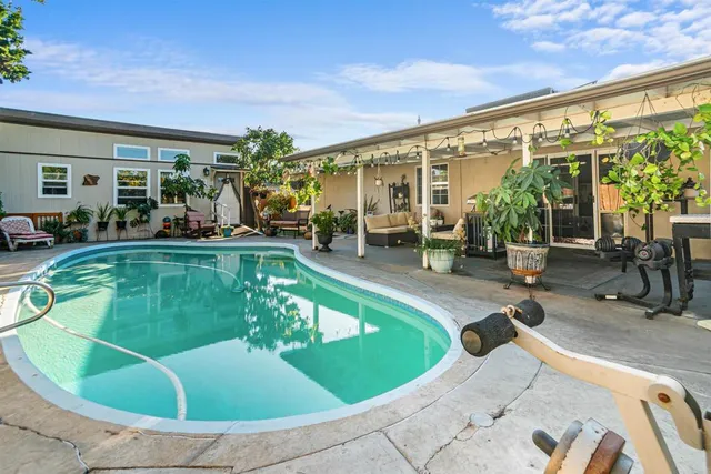 a view of a swimming pool with chairs in patio