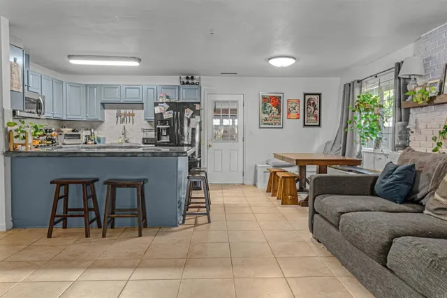 a living room with furniture and a kitchen view