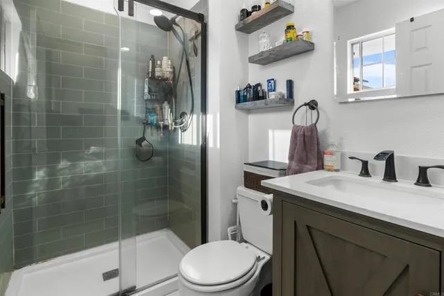 a bathroom with a sink a toilet and shower