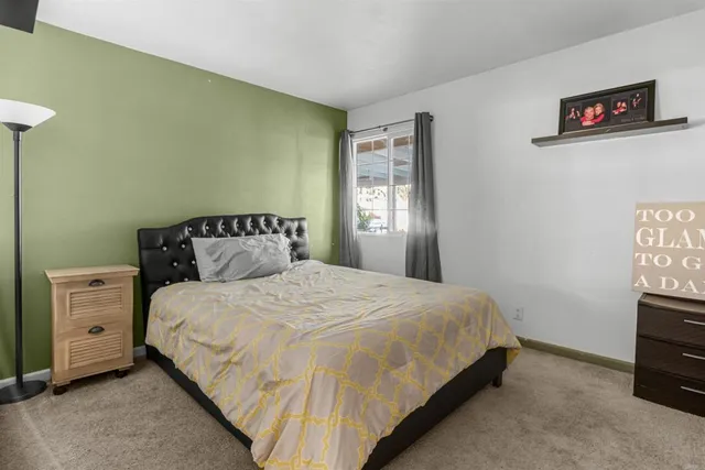 a bedroom with a bed and a tv on the dresser