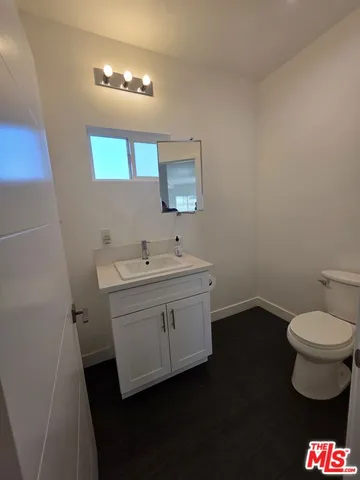 a bathroom with a sink toilet and a mirror