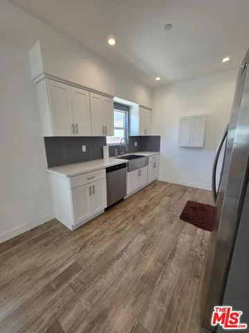 a large kitchen with a large counter top space stainless steel appliances and cabinets