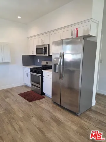 a kitchen with stainless steel appliances granite countertop a refrigerator a stove and a sink