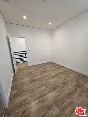an empty room with wooden floor and white walls