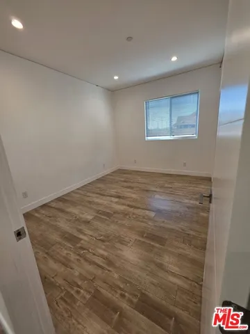 an empty room with wooden floor and cabinet