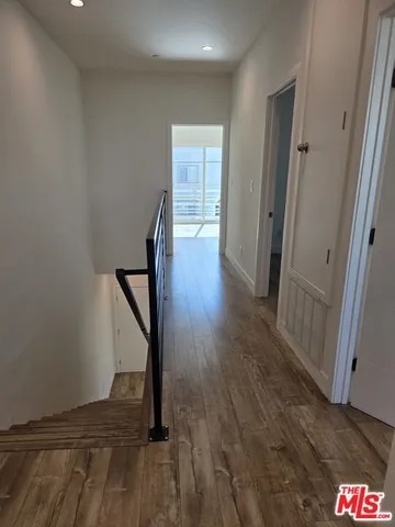 a view of a hallway with wooden floor and staircase