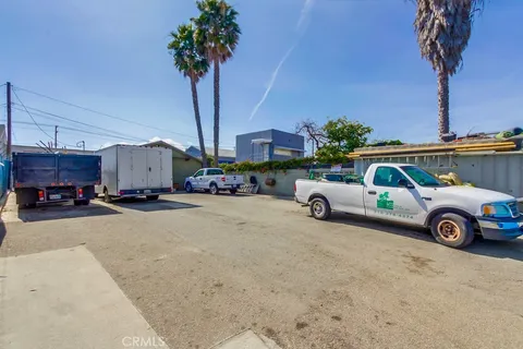 a house view with a sitting space and palm trees