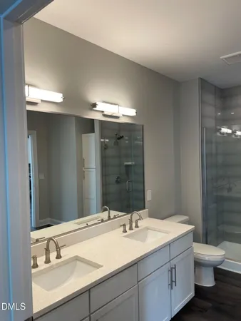 a bathroom with a double vanity sink toilet and a mirror