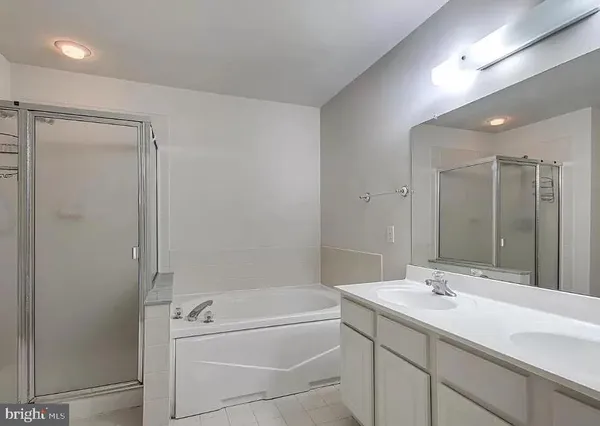a bathroom with a tub sink shower and mirror