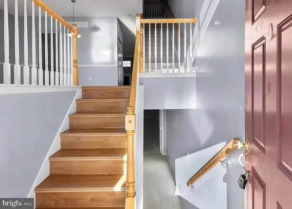 a view of staircase with lots of frames on wall and a large window