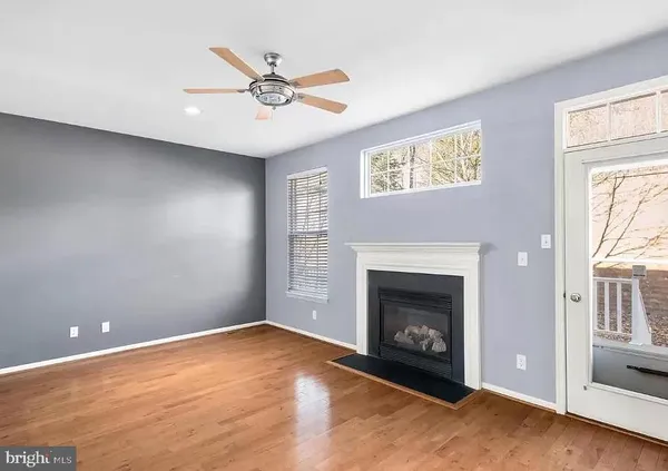 a view of an empty room with chandelier fan and fire place