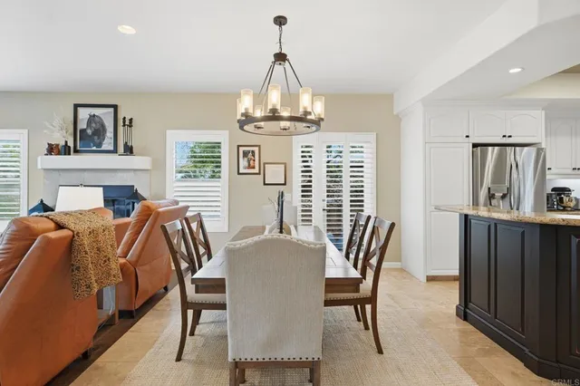 a dining hall with stainless steel appliances granite countertop a table chairs and view living room