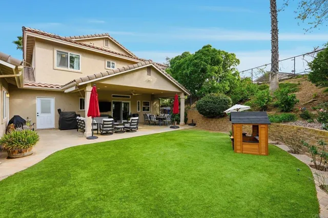 an aerial view of residential houses with outdoor space and trees