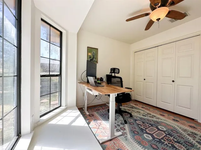 a view of a workspace with furniture and a window