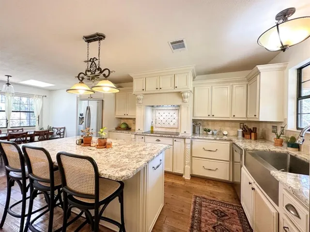 a kitchen with granite countertop kitchen island dining table and stainless steel appliances
