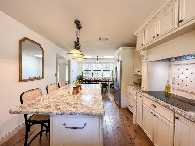 a large kitchen with kitchen island a stove a sink a dining table and chairs