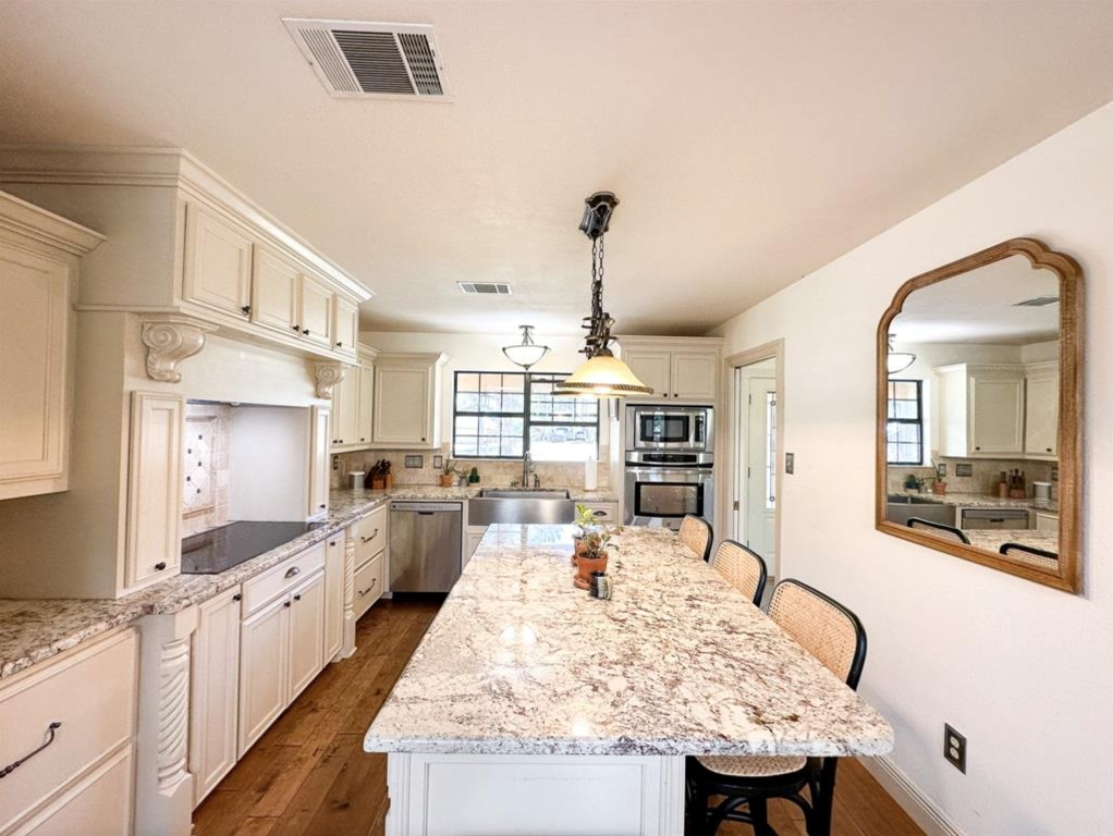 251 Pine View Loop Bastrop, TX 78602 - Photo 10 of 30 a large kitchen with kitchen island a stove a sink a dining table and chairs