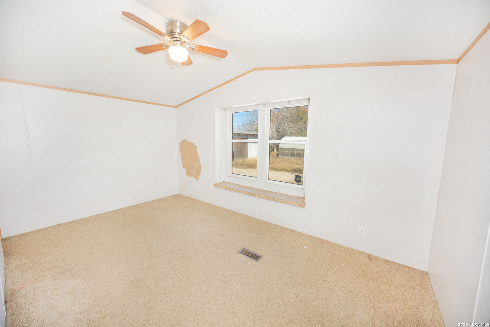 4919 County Road 545 Devine, TX 78016 - Photo 13 of 38 a view of a room with a ceiling fan and a window
