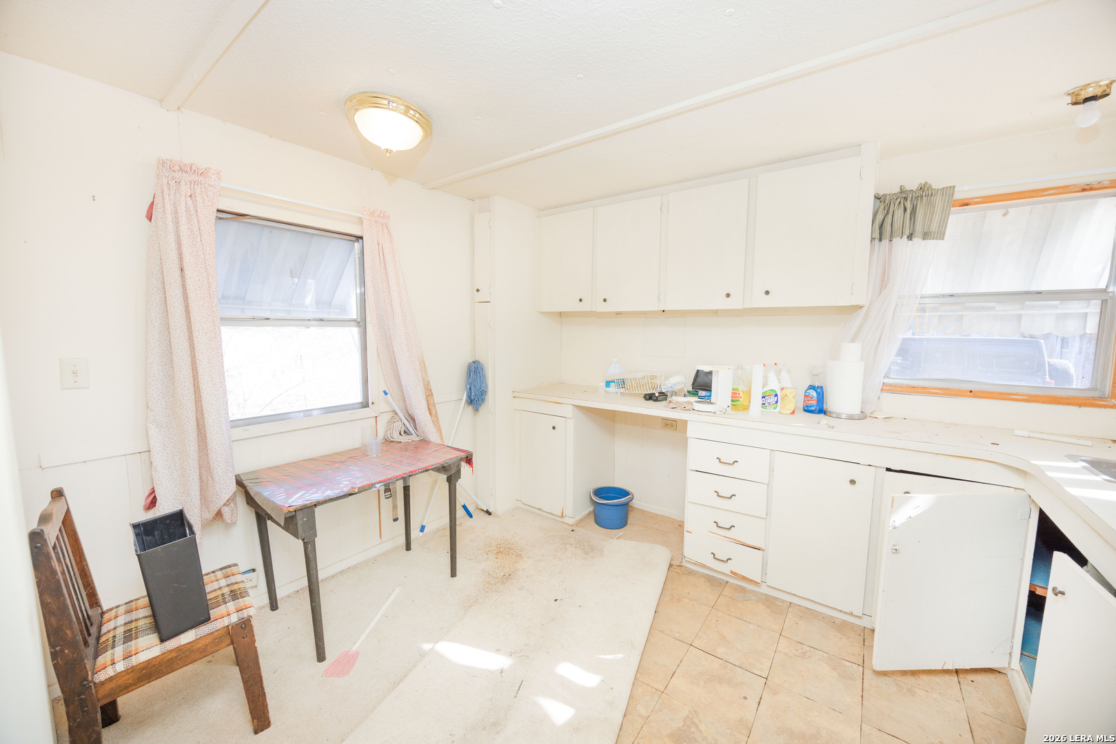 4919 County Road 545 Devine, TX 78016 - Photo 15 of 38 a kitchen with a chair and white cabinets