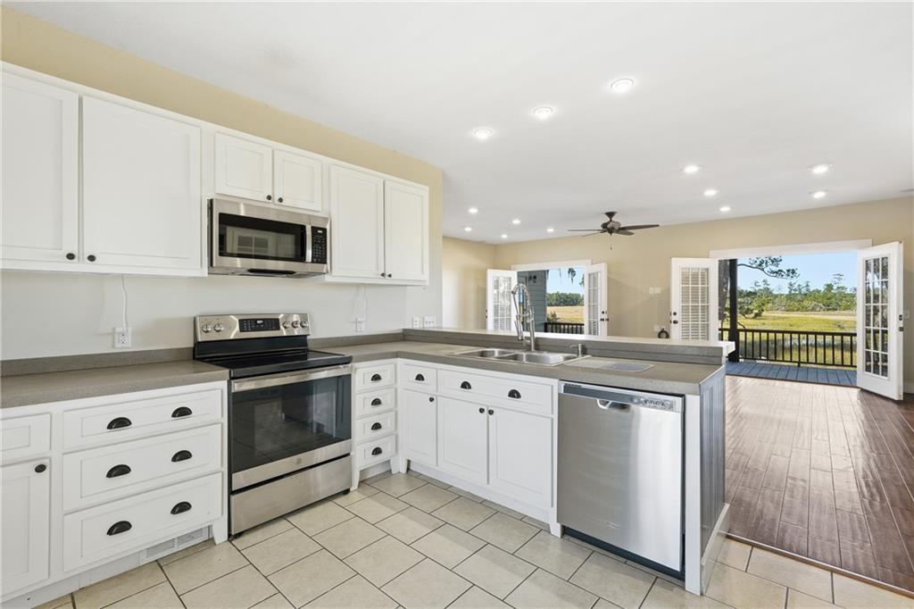 1261 Otter Slide Loop Townsend, GA 31331 - Photo 18 of 52 a kitchen with granite countertop a sink and steel appliances