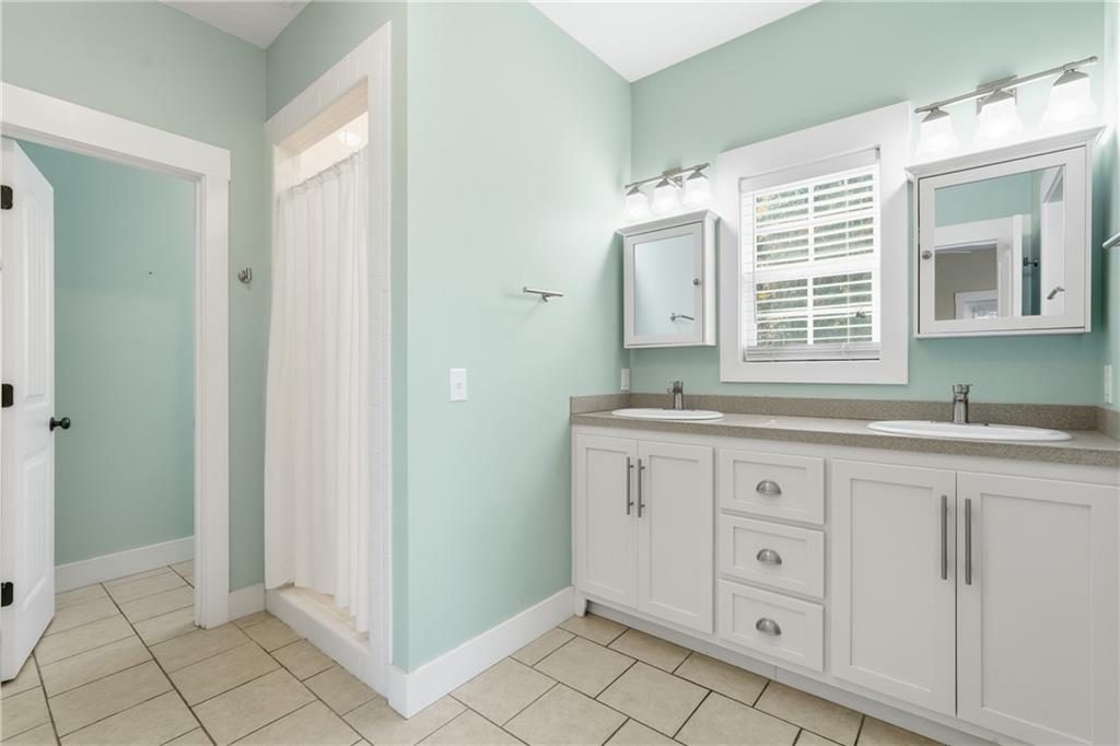 1261 Otter Slide Loop Townsend, GA 31331 - Photo 29 of 52 a spacious bathroom with a granite countertop sink and a mirror