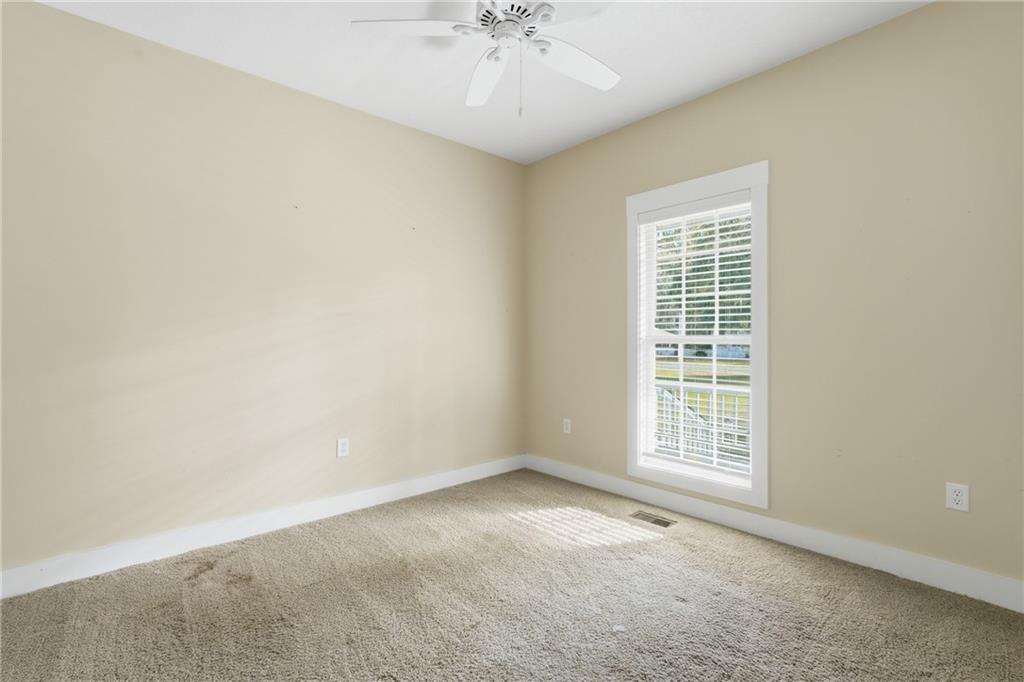 1261 Otter Slide Loop Townsend, GA 31331 - Photo 31 of 52 an empty room with a chandelier fan and windows