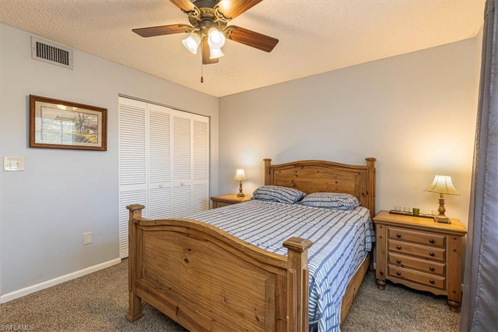 5535 Rattlesnake Hammock Road, Unit 302 Naples, FL 34113 - Photo 16 of 24 a bedroom with a bed and a chandelier