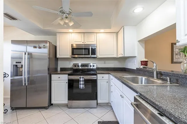 a kitchen with stainless steel appliances granite countertop a sink stove microwave and refrigerator