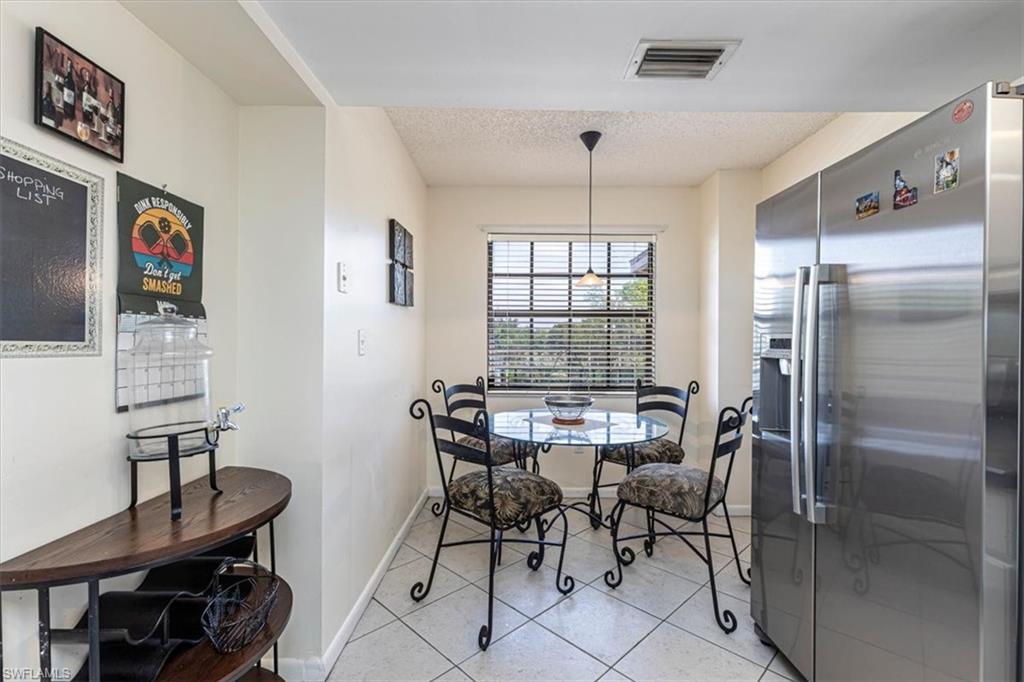 5535 Rattlesnake Hammock Road, Unit 302 Naples, FL 34113 - Photo 19 of 24 a view of a dining room with furniture window and wooden floor