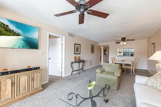a living room with furniture and a dining table